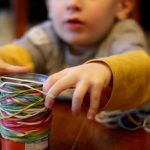 A child playing with rubber bands