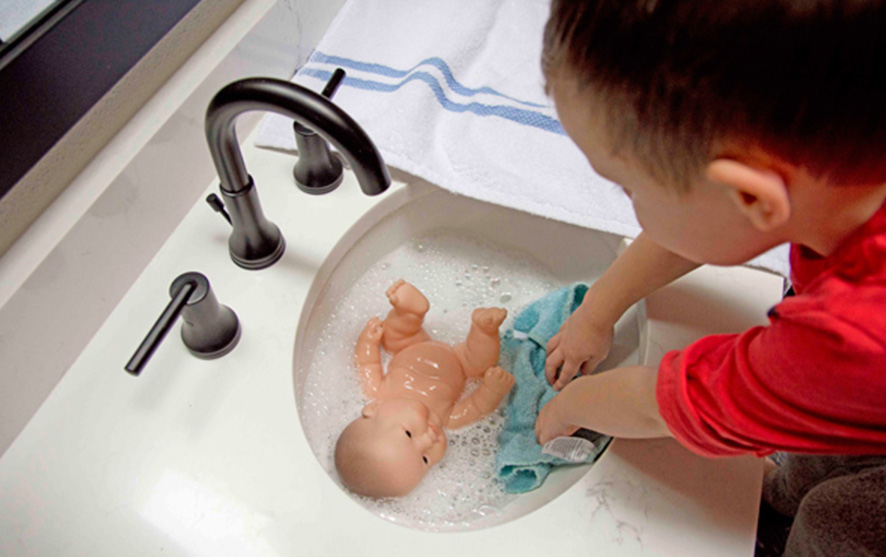 A child giving a doll a bath