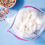 Ice cream in a bag and sprinkles in a bowl next to it