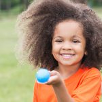 A girl holding an egg in a spoon for an egg and spoon race