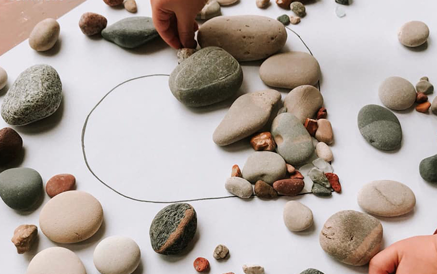 Rocks on a piece of paper arranged in the shape of a heart