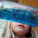 A girl holding a blue ocean bottle