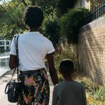 A woman and a child walking down the street