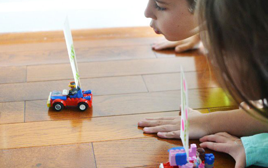 Children playing wind race cars