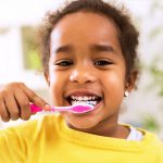 A little girl brushing her teeth