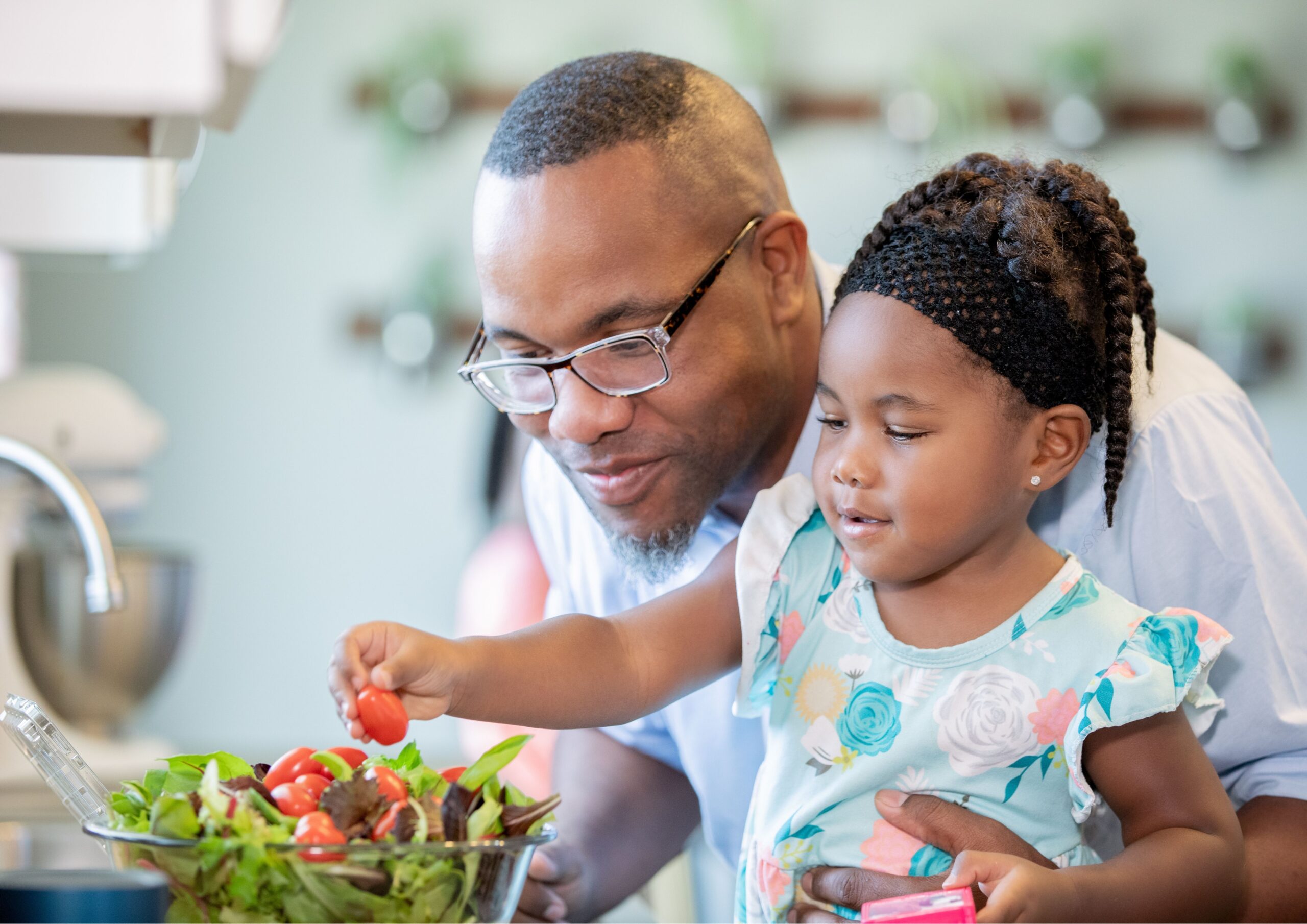 A dad and a daughter eating a salad