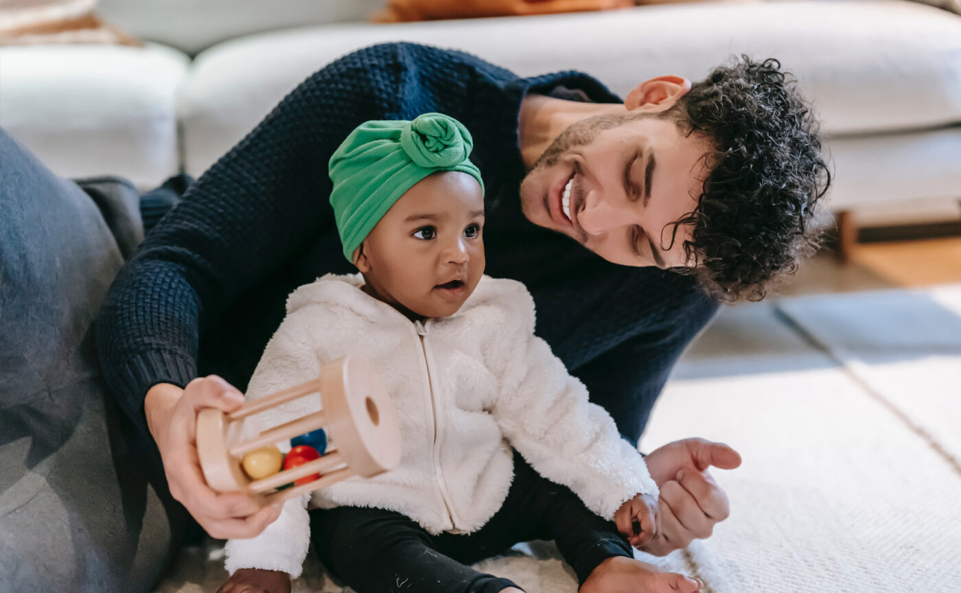 A dad playing with his baby daughter