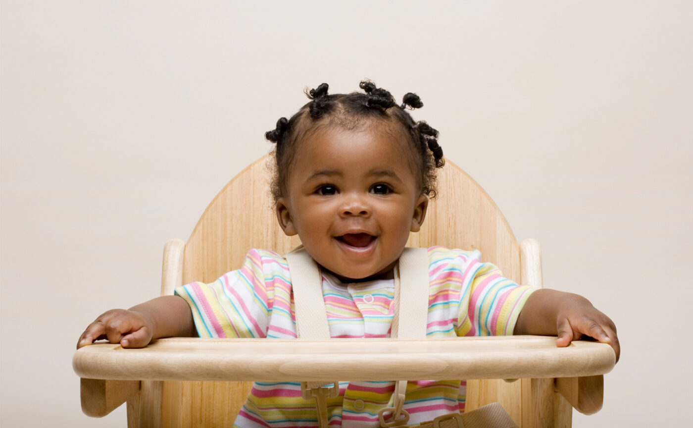 A small child sitting in a feeding chair