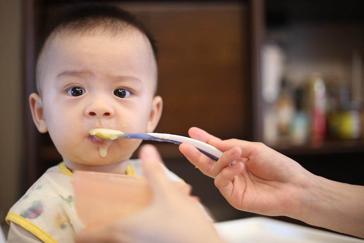 Baby eating food for article on fussy eating