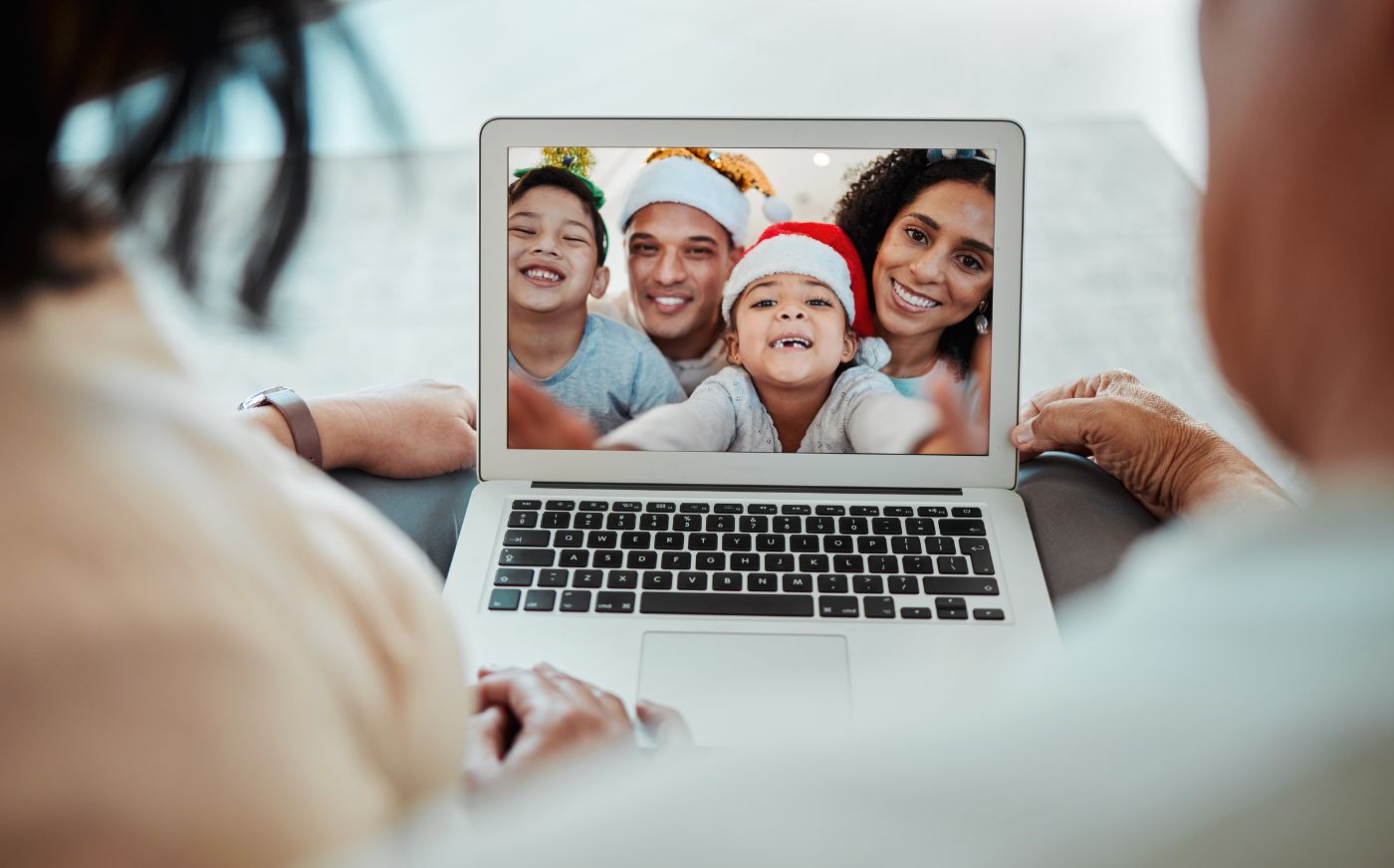 A couple looking at a laptop during a video call with family