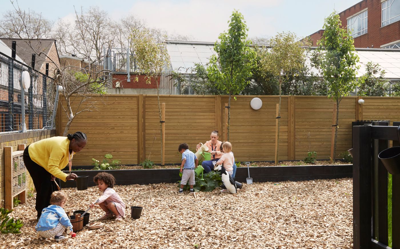 Nursery educators and children gardening in a nursery garden